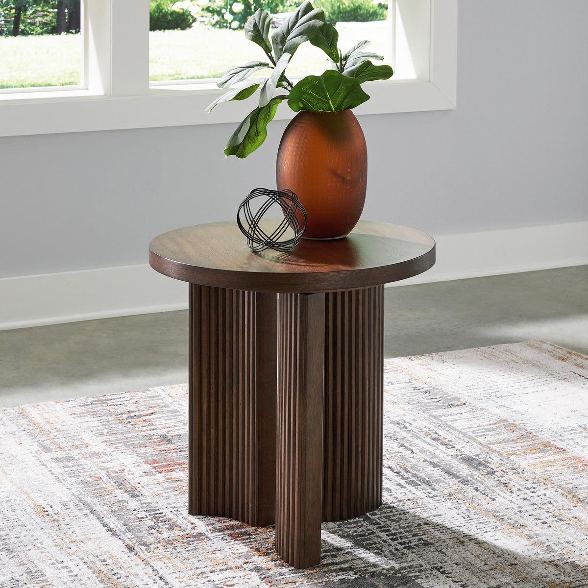 A room setting featuring Korestone Brown Round End Table
