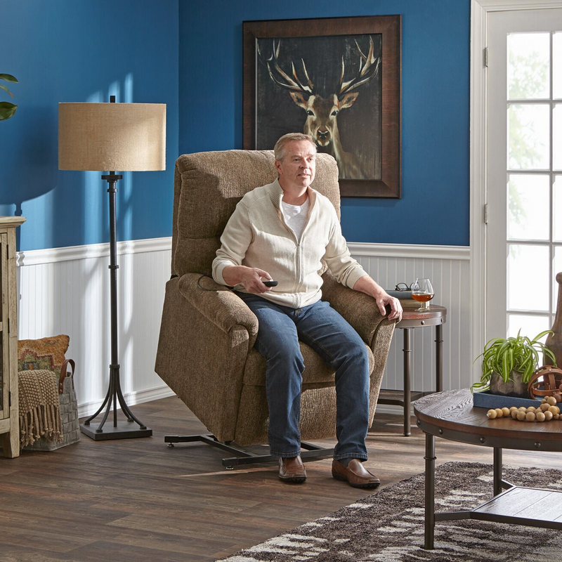 Man sitting in a recliner chair in a living room with blue walls and a deer painting.